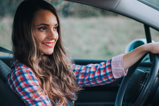 Woman driving card with a smile